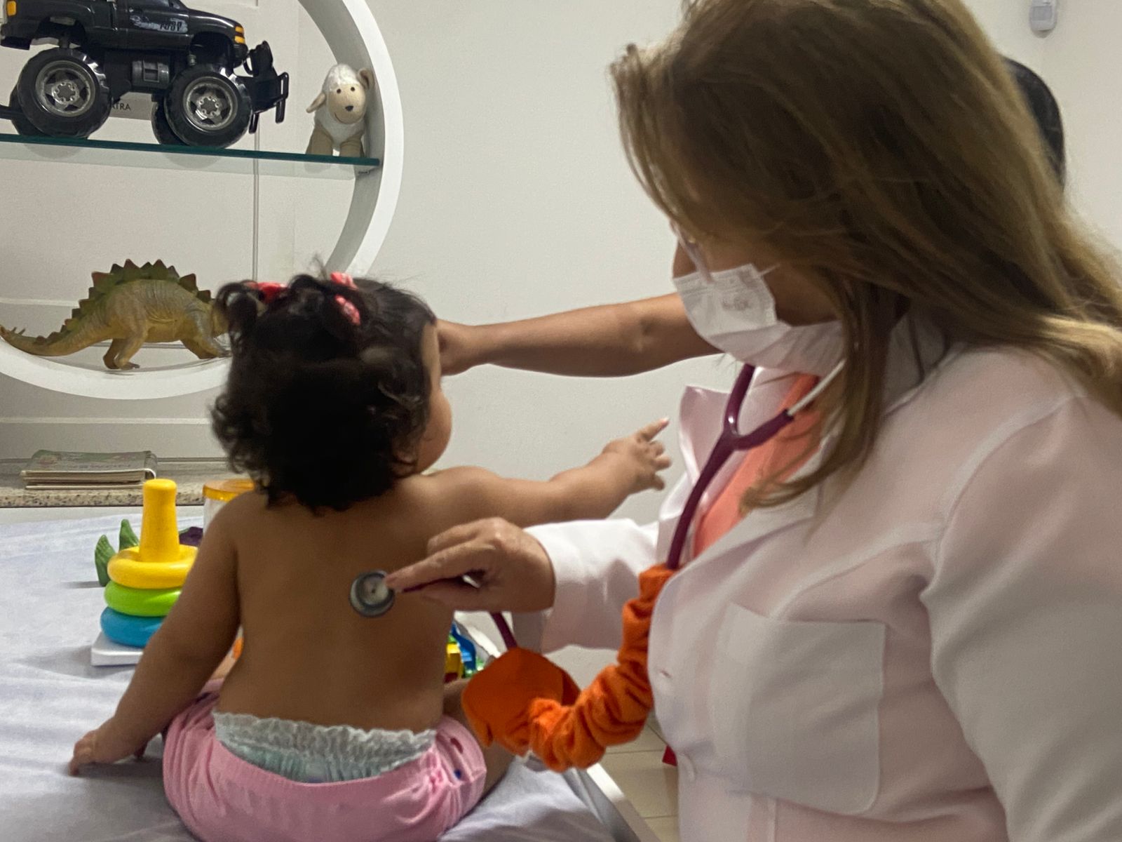 Dra. Giovana Melo examinando bebê durante consulta pediátrica